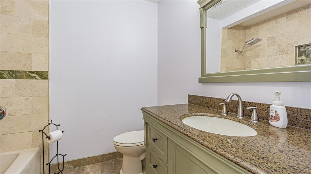3801 Durant Road Valrico, FL 33596 - Photo 15 of 53 a bathroom with a granite countertop sink a toilet and a mirror