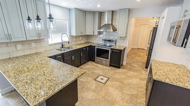 a kitchen with stainless steel appliances granite countertop a sink stove and refrigerator