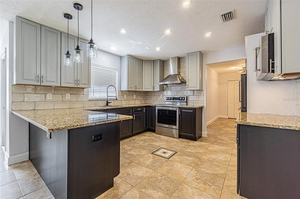 3801 Durant Road Valrico, FL 33596 - Photo 2 of 53 a kitchen with stainless steel appliances granite countertop a sink stove and refrigerator
