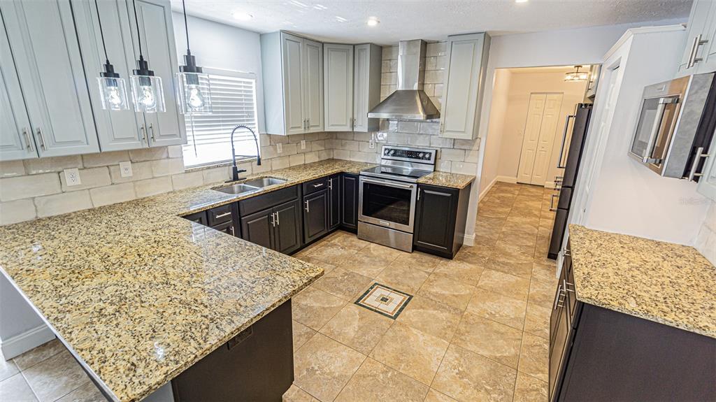 3801 Durant Road Valrico, FL 33596 - Photo 23 of 56 a kitchen with stainless steel appliances granite countertop a sink stove and refrigerator