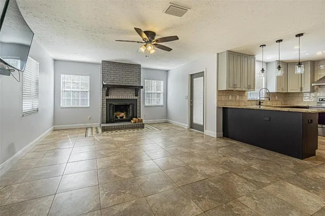 a view of an empty room with a fireplace and a window