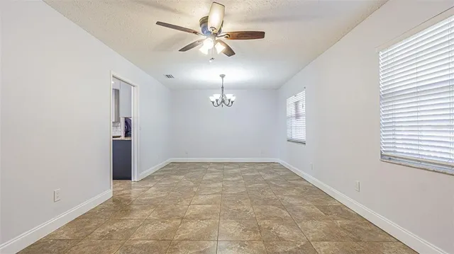 an empty room with fan and windows