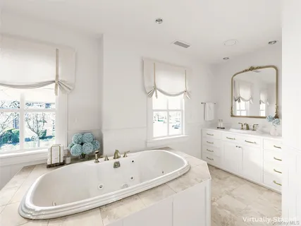 a bathroom with a tub a sink and a window
