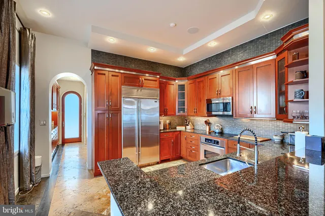 a kitchen with granite countertop a refrigerator and a sink
