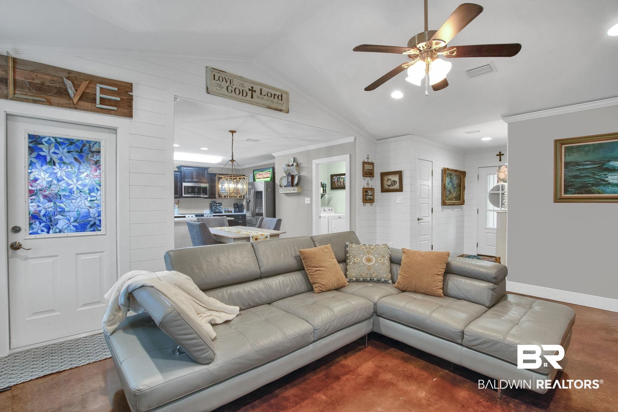 203 Lakefront Circle Summerdale, AL 36580 - Photo 17 of 69 Carpeted living room with ceiling fan with notable chandelier, lofted ceiling, wood walls, and ornamental molding