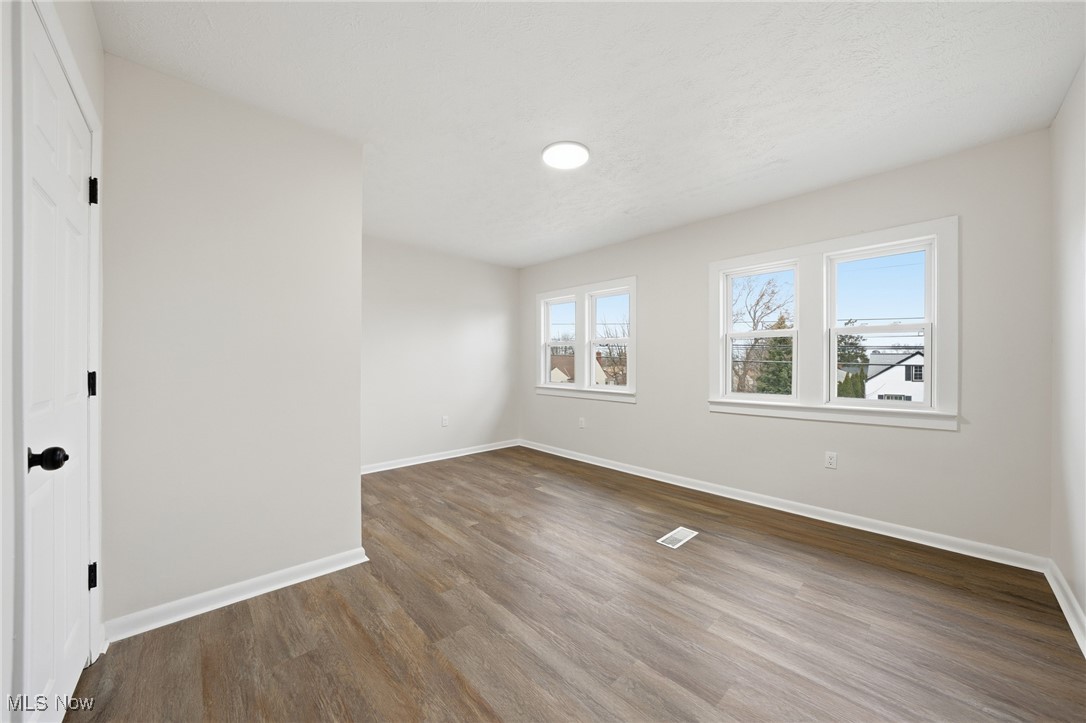 7911 Snow Road Parma, OH 44129 - Photo 27 of 44 Unfurnished bedroom with multiple windows and wood finished floors