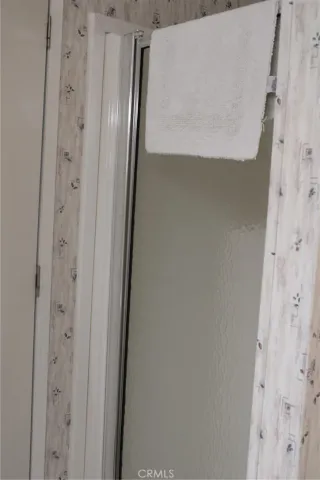 a bedroom with a bed and a lamp on dresser