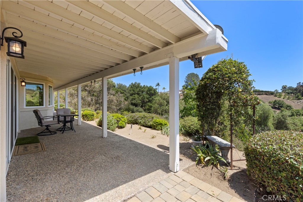 3237 Canonita Drive Fallbrook, CA 92028 - Photo 32 of 55 a view of a patio with table and chairs potted plants with wooden floor and fence