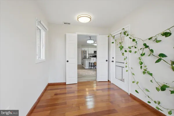 a view of a hallway view with wooden floor and a potted plant