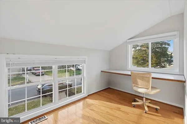 a view of a room with wooden floor and windows