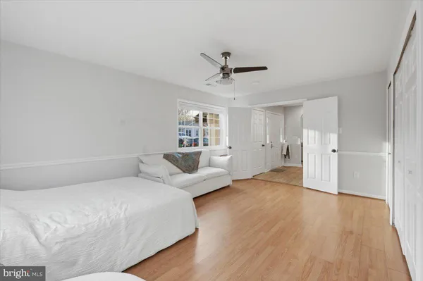 a spacious bedroom with a bed and wooden floor