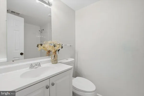 a bathroom with a sink vanity mirror and toilet