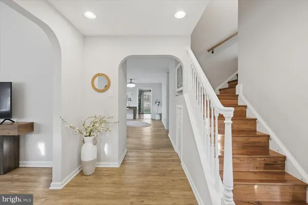 a view of a hallway with wooden floor and a potted plant