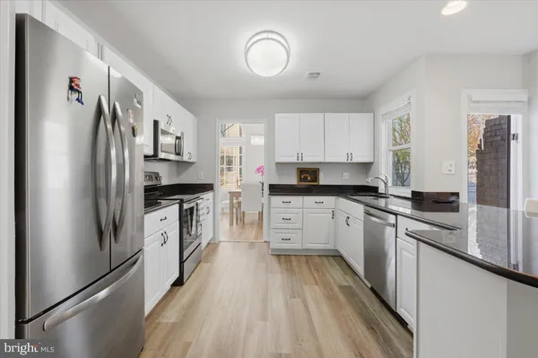 a kitchen with stainless steel appliances a refrigerator sink and cabinets
