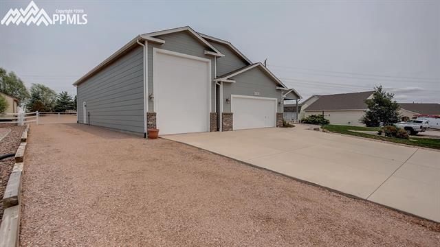 9232 Rockingham Drive Peyton, CO 80831 - Photo 2 of 35 Oversized 2 car garage and a tandem 3 car RV garage w extra parking to the side.
