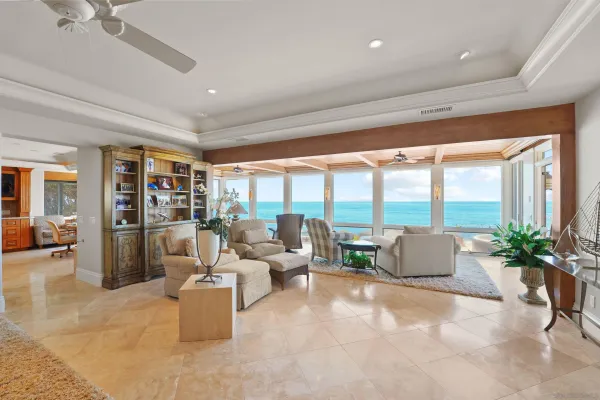a living room with furniture a chandelier and a floor to ceiling window