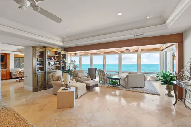 a living room with furniture a chandelier and a floor to ceiling window