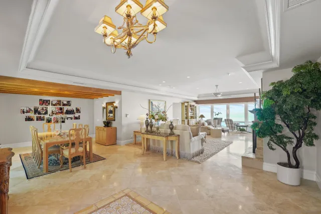 a dinning room with furniture a kitchen and chandelier