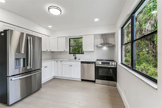 a kitchen with stainless steel appliances granite countertop a refrigerator sink and stove