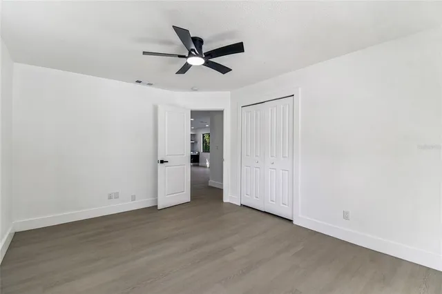 a view of a livingroom with a ceiling fan window and wooden floor