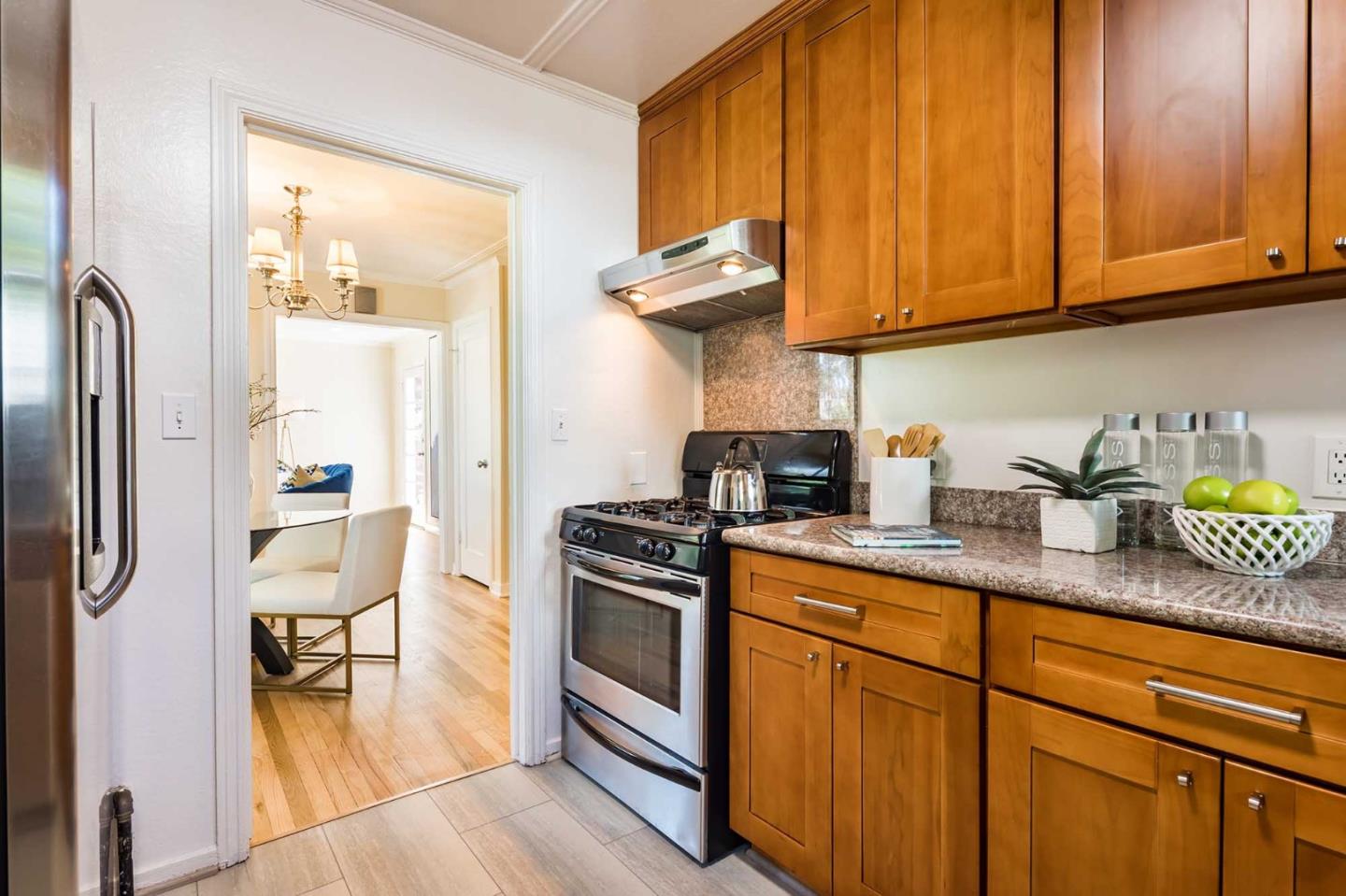 1110 Embarcadero Road Palo Alto, CA 94303 - Photo 11 of 23 a kitchen with stainless steel appliances granite countertop a stove a sink dishwasher and microwave with wooden cabinets