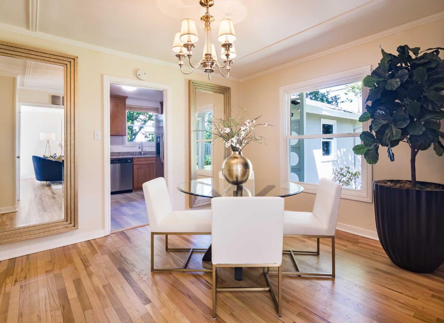 1110 Embarcadero Road Palo Alto, CA 94303 - Photo 10 of 23 a dining room with wooden floor a chandelier a wooden table and chairs