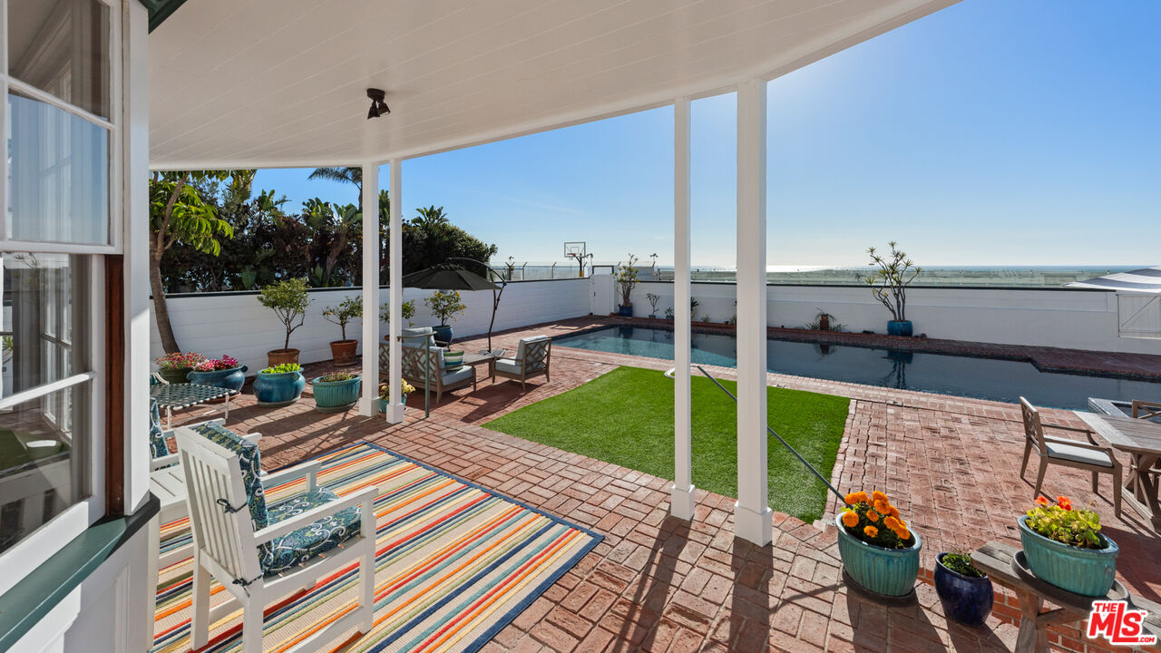 605 Palisades Beach Road Santa Monica, CA 90402 - Photo 14 of 33 a view of a patio with table and chairs potted plants with wooden floor and fence
