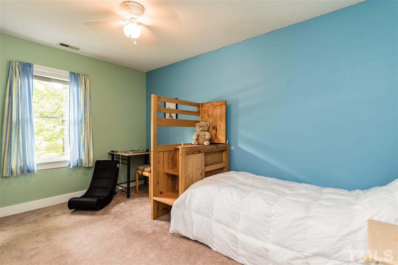 2228 Bufflehead Road Raleigh, NC 27616 - Photo 15 of 20 a bedroom with a bed and a chandelier