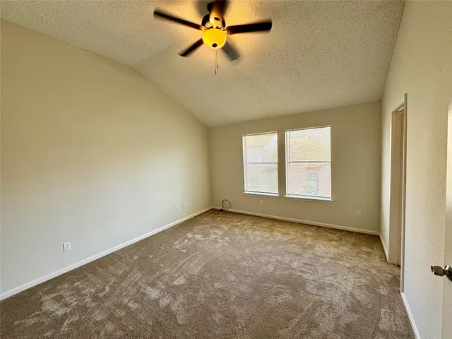 an empty room with a window and a fan