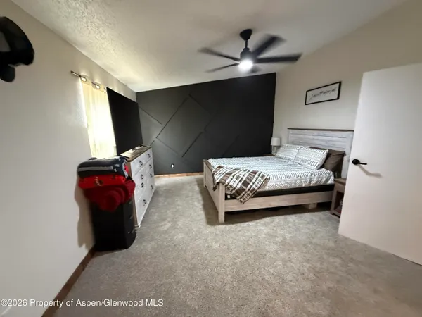 a bedroom with a bed and a painting on the wall