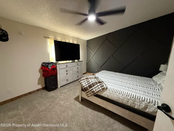 a spacious bedroom with a bed and a flat screen tv