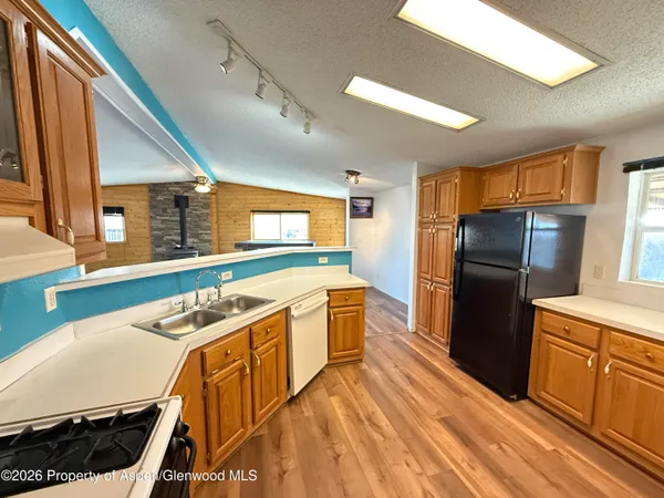 a kitchen with stainless steel appliances granite countertop a refrigerator a stove and a sink