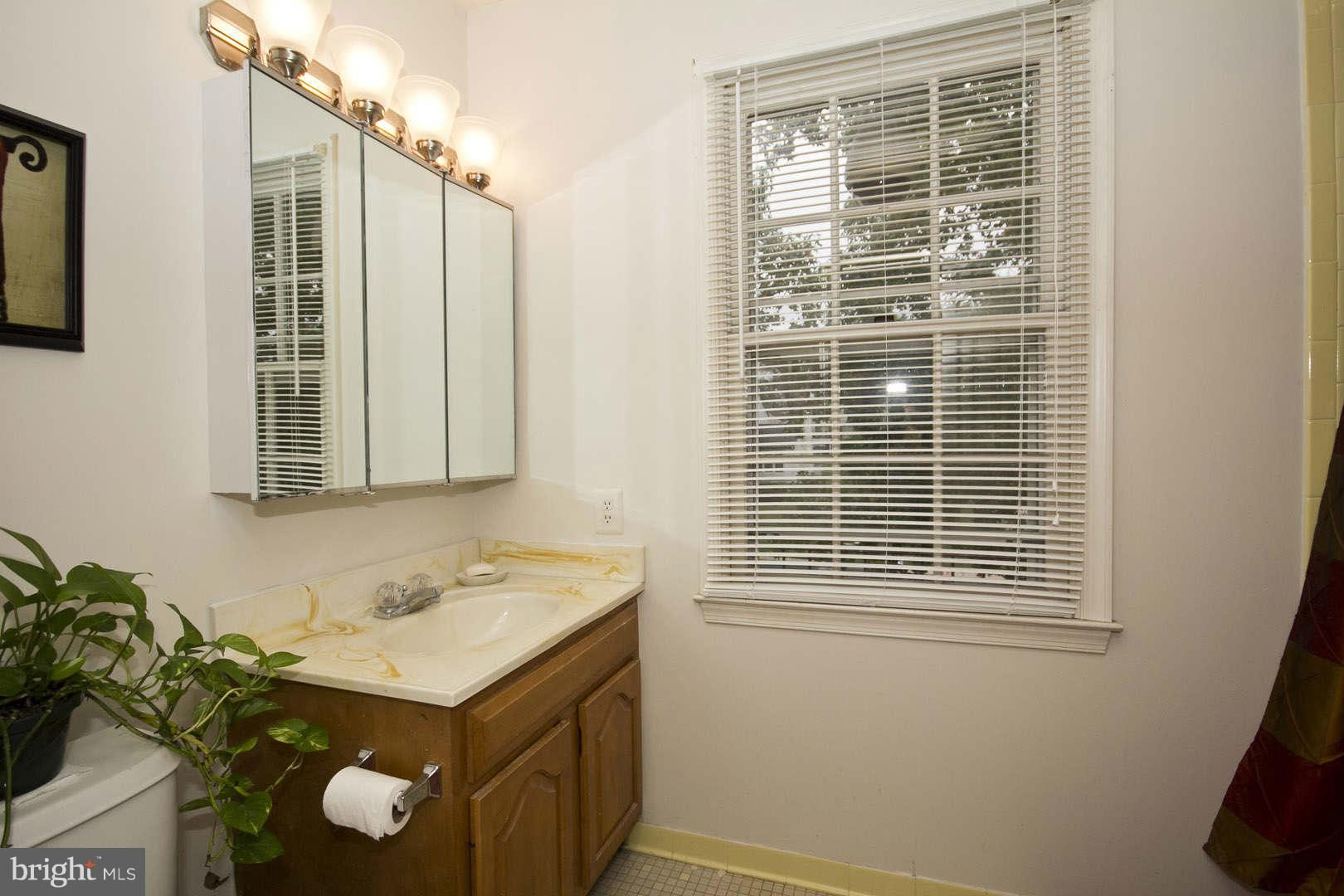 13608 Turnmore Road Silver Spring, MD 20906 - Photo 22 of 30 a bathroom with a sink mirror and a window