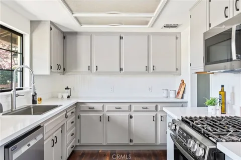 a kitchen with white cabinets and black appliances