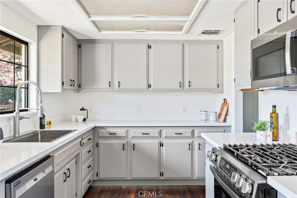 6030 Portola Road Atascadero, CA 93422 - Photo 12 of 44 a kitchen with white cabinets and black appliances