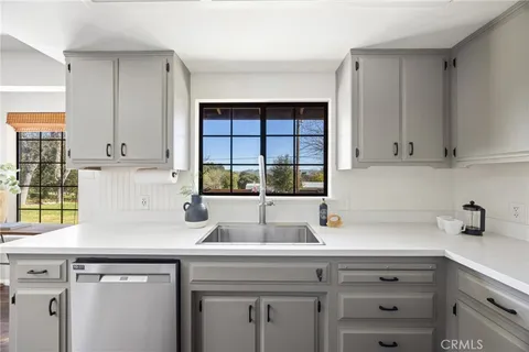 a kitchen with stainless steel appliances white cabinets and a window