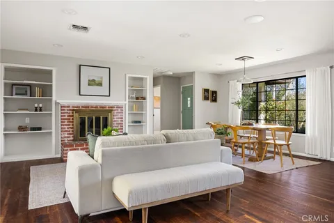 a living room with fireplace furniture and a large window
