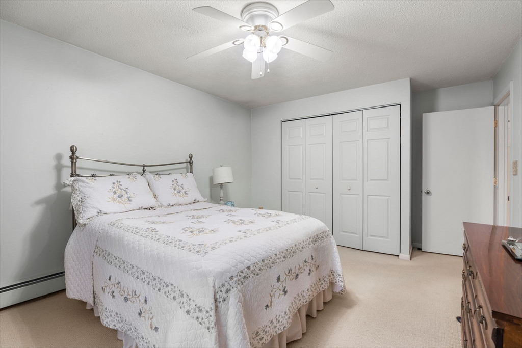 62 Purchase Street, Unit C5 Danvers, MA 01923 - Photo 15 of 22 a bedroom with a bed and a chandelier