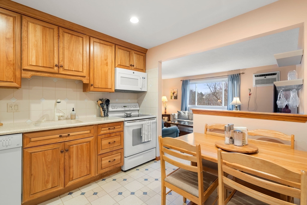 62 Purchase Street, Unit C5 Danvers, MA 01923 - Photo 5 of 22 a kitchen with stainless steel appliances kitchen island granite countertop a sink and cabinets
