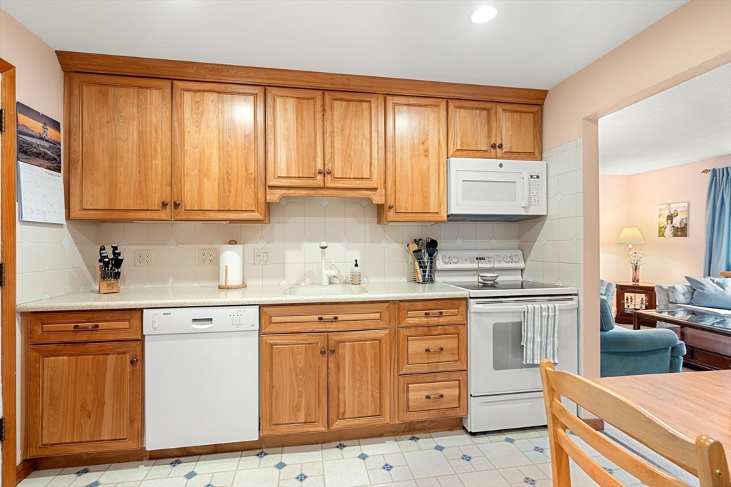 62 Purchase Street, Unit C5 Danvers, MA 01923 - Photo 6 of 22 a kitchen with stainless steel appliances granite countertop a stove a sink dishwasher and cabinets with wooden floor
