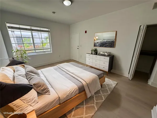 a bedroom with a bed and a flat tv screen on a dresser