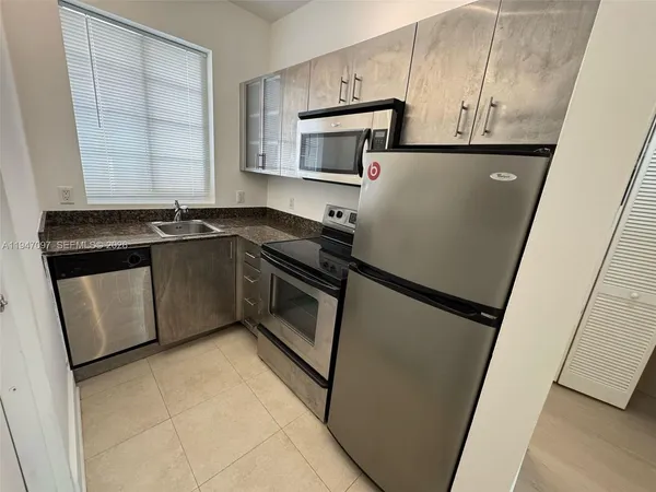 a kitchen with stainless steel appliances a refrigerator sink and microwave