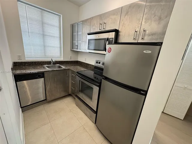 a kitchen with stainless steel appliances a refrigerator sink and microwave