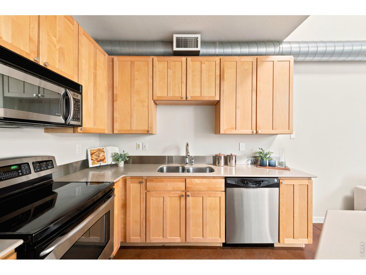 3033 Blake Street, Unit 112 Denver, CO 80205 - Photo 12 of 28 a kitchen with stainless steel appliances a stove a sink a microwave and cabinets