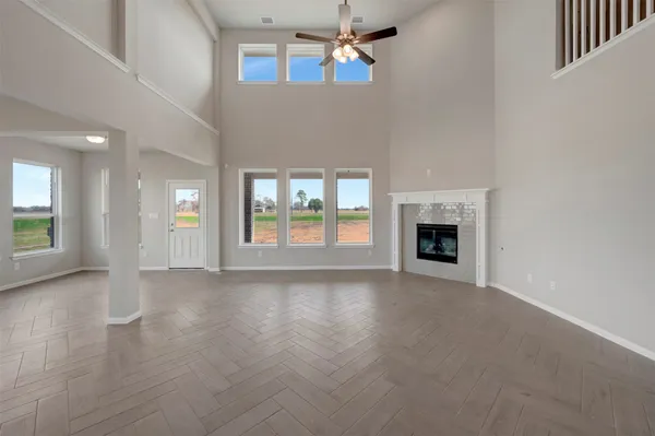 an empty room with windows and fireplace