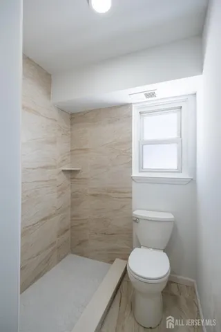 a bathroom with a toilet and a shower