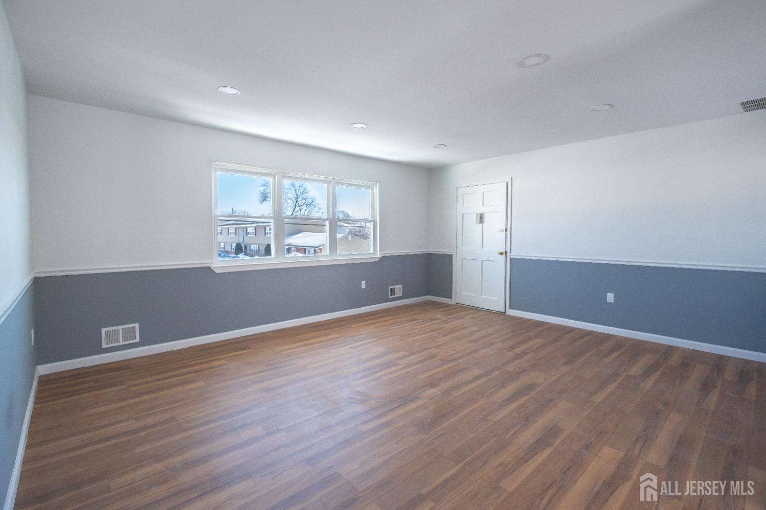 72 Haven Drive, Unit D Matawan, NJ 07747 - Photo 10 of 12 a view of wooden floor and windows in a room