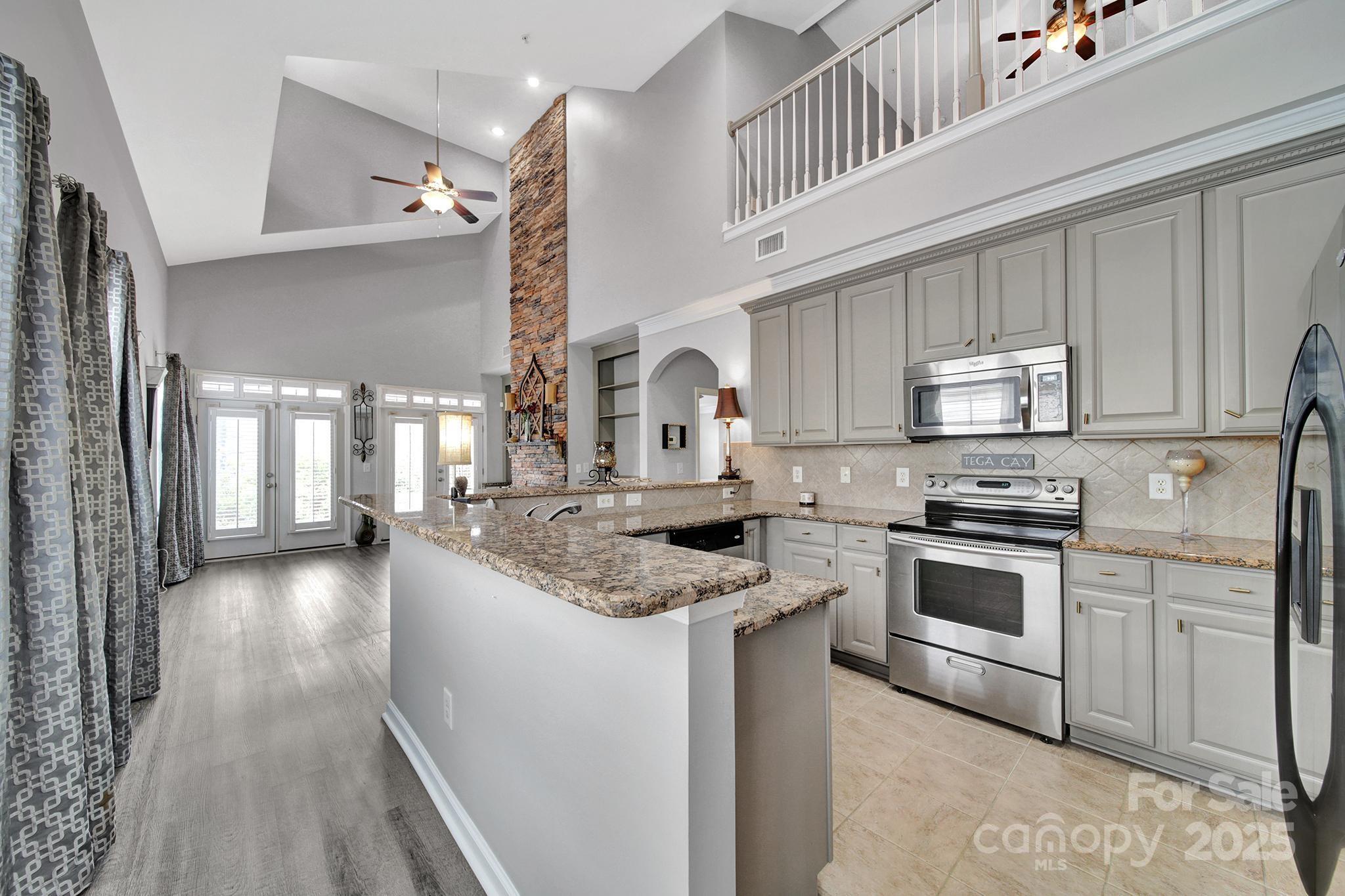 314 Wave Crest Drive Tega Cay, SC 29708 - Photo 5 of 39 a kitchen with granite countertop a stove sink and cabinets