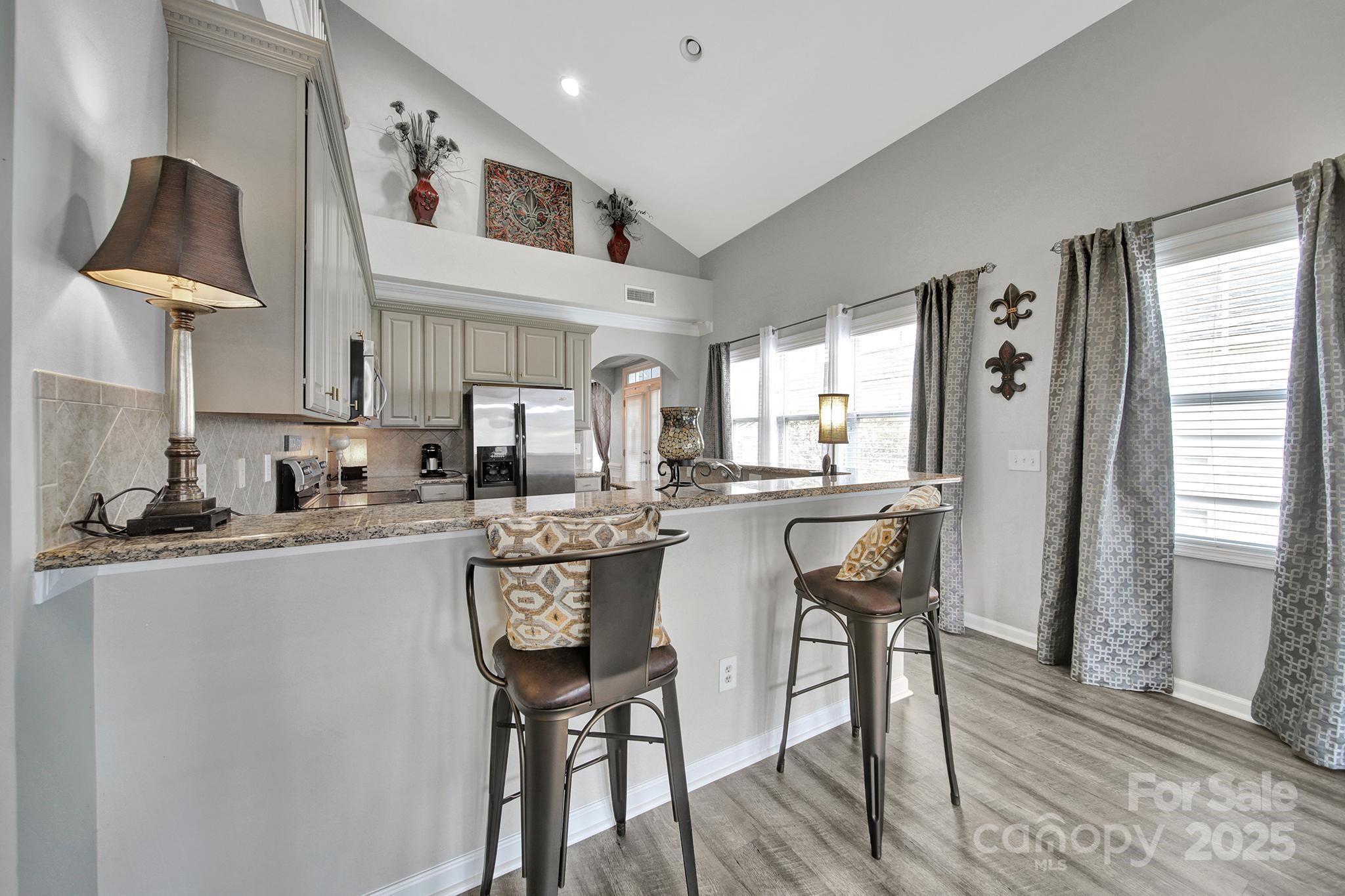 314 Wave Crest Drive Tega Cay, SC 29708 - Photo 8 of 39 a kitchen with stainless steel appliances granite countertop a table chairs refrigerator and sink