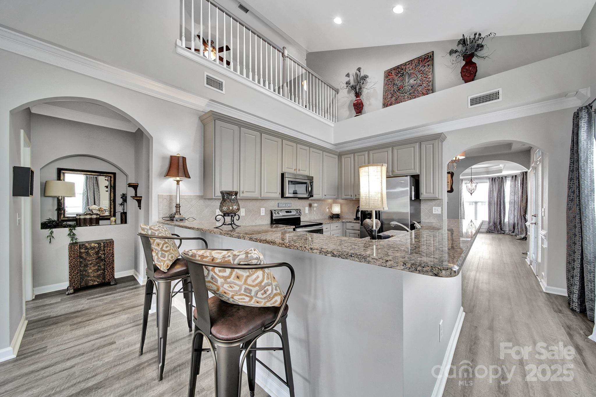 314 Wave Crest Drive Tega Cay, SC 29708 - Photo 9 of 39 a kitchen with sink a refrigerator and chairs